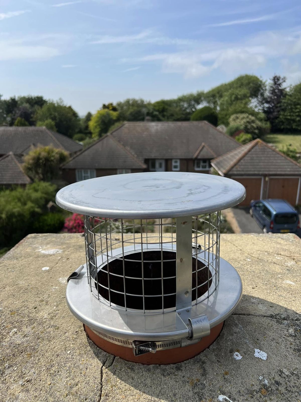 Stainless steel mesh cowl fitted to a chimney pot above Seaford rooftops